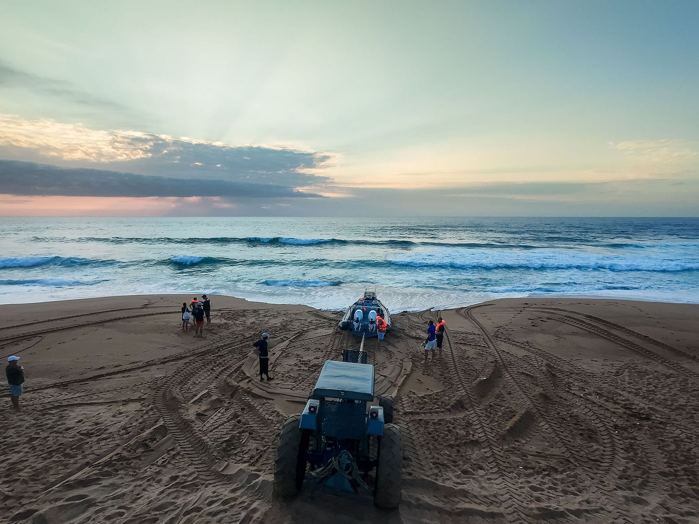 Aerial view of a tractor towing a rigid inflatable boat up the beach at Westbrook after a run